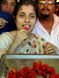 赤唐辛子を食べるインド人女性
